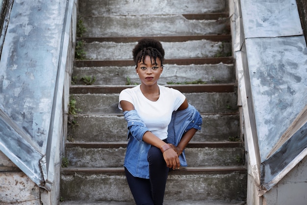 Dark-skinned girl sits in the ghetto