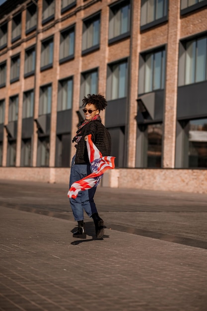 A dark-skinned girl with american flag in hands