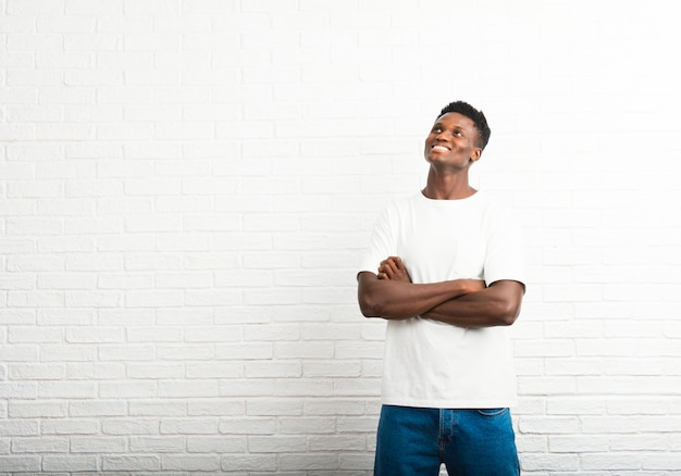 Dark skinned man stand and looking up while smiling