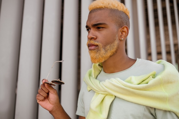 A dark-skinned model with a dyed beard posing for the camera