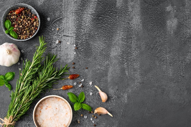 Dark stone cooking background Spices basil rosemary and garlic Top view Free space for your text