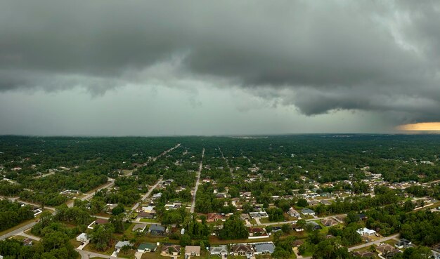 Dark stormy clouds forming on gloomy sky before heavy rainfall over suburban town area