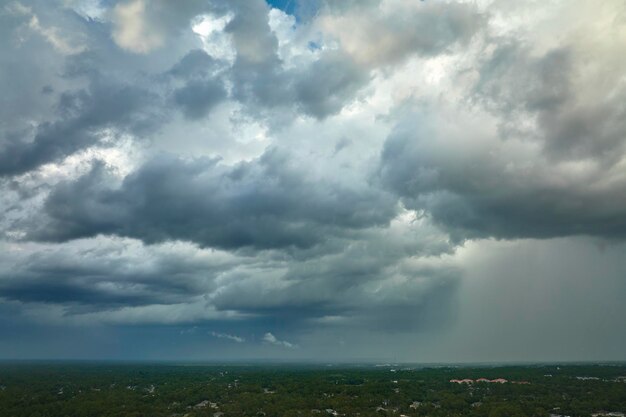 写真 郊外の町の大雨の前に暗い空に形成される暗い嵐の雲