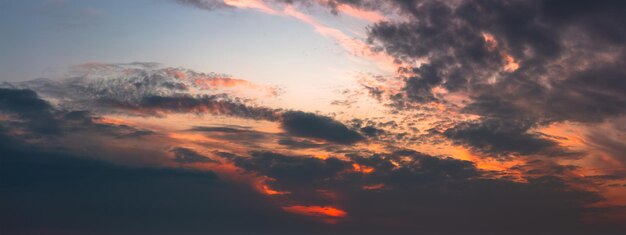 Dark sunset with gloomy clouds and red light on the horizon