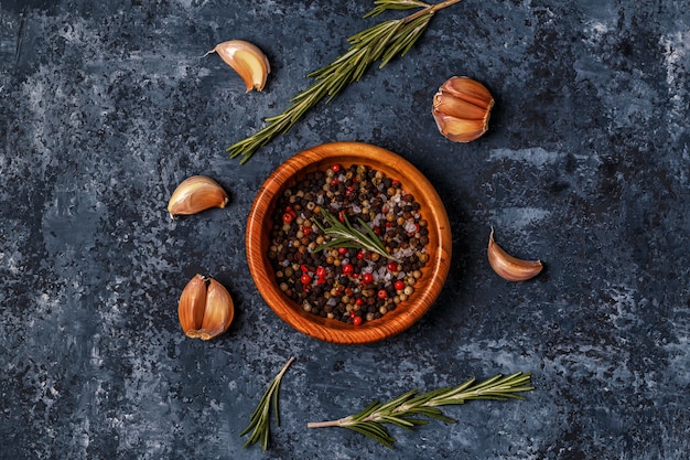 Dark surface with rosemary, garlic and pepper