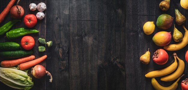 Dark wooden background with fruits vegetables on the sides Banner for greengrocers and supermarkets