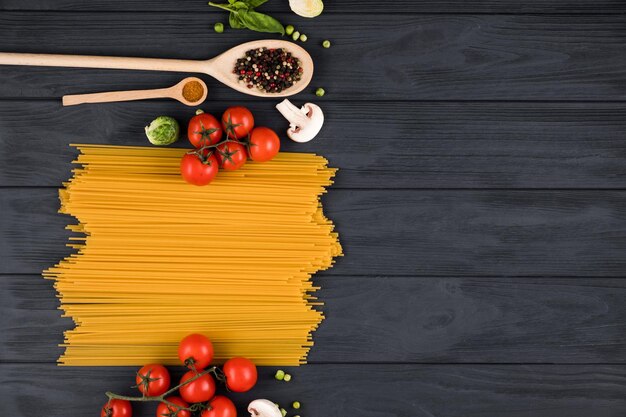 Photo on a dark wooden board are laid out ingredients for an italian dish