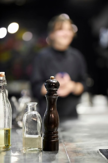 dark wooden pepper grinder on the table, blurred background. wooden salt shaker on bokeh background.