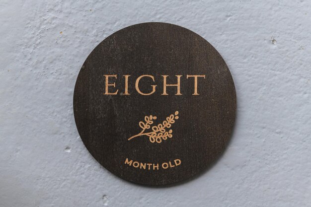 Dark wooden round board with the inscription eight on a gray background