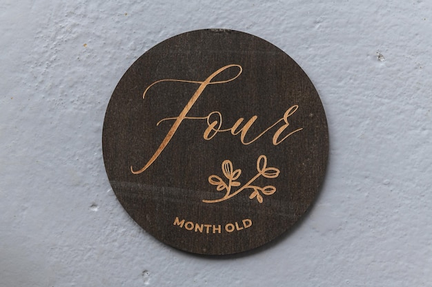 Dark wooden round board with the inscription four on a gray background