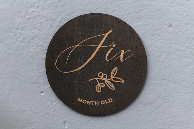 Dark wooden round board with the inscription six on a gray background