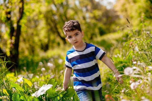 Photo a darkhaired boy walking in the park