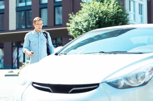 Darkhaired businessman opening his car while heading to work