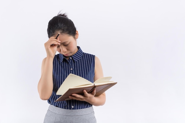 Darkhaired woman in knitted sweater looks up thoughtfully Lady thinks what to write in new book