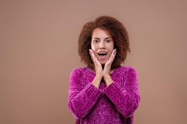 Darkhaired young woman looking happy and surprised