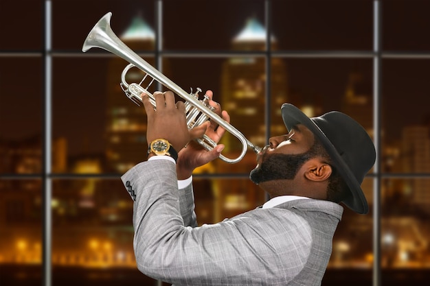 Photo darkskinned trumpeter in fedora hat.