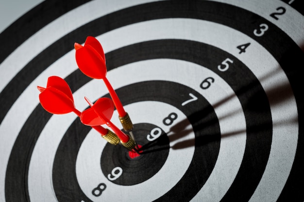 Dart arrow hitting in the target center of dartboard