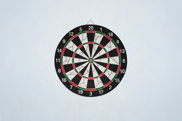 Dartboard on blue wall. Darts a series of related games in which players throw Darts at a round target hung on the wall.