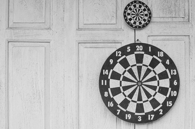 Photo the darts board on white wooden background.