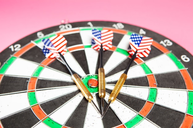 Darts and darts on a pink background. goal concept