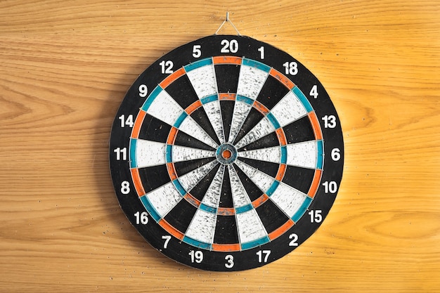 Darts Stuck On Dartboard Mounted On Brick Wall