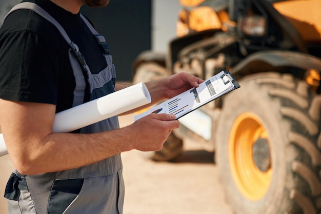 Photo data in the notepad reading man is with tractor agricultural worker