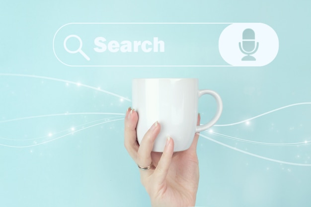 Технология поиска данных Поисковая оптимизация. Обрезанный вид женской руки с белой кофейной чашкой и знаком поиска адреса и значка панели навигации на синем фоне.