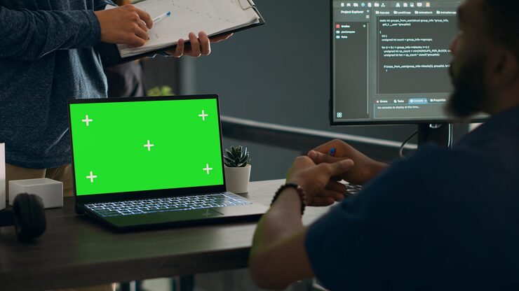 Photo database admins analyzing source code and greenscreen display on computer to develop software algorithm in busy space. cloud programers working with chromakey template isolated copyspace.