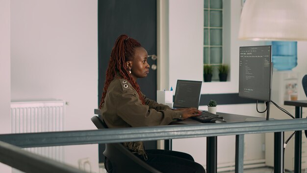 Databaseprogrammeur schrijft broncode en script in terminalvenster, werkt met computer die coderingsalgoritme weergeeft. Softwareontwikkelaar programmeert big data in bureau van het agentschap.