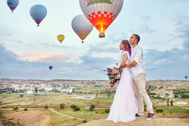 Date of a couple in love at sunset against of balloons in Cappadocia