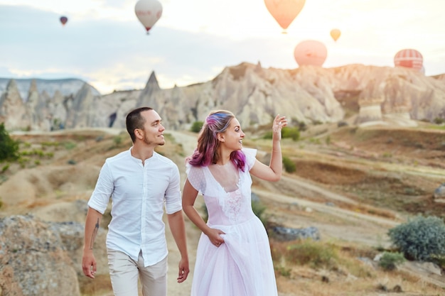 Date of a couple in love at sunset against of balloons in Cappadocia