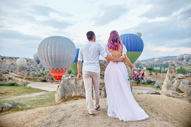 Foto data della coppia in amore al tramonto contro i palloncini