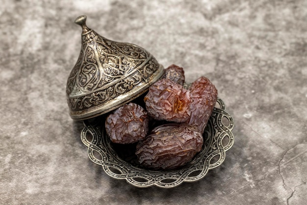 Date fruit on a dark background date fruits on a rustic serving\
plate