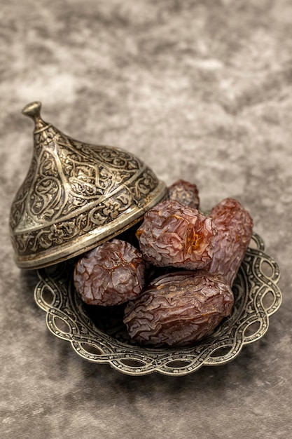 Date fruit on a dark background date fruits on a rustic serving\
plate