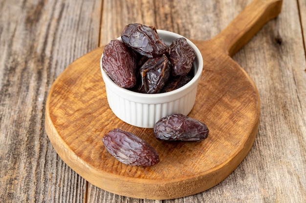 Date fruit in a plate Date fruit on wood background Organic and fresh nuts close up