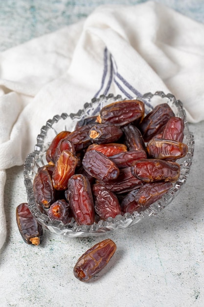 Date fruit on stone background Organic Medjoul dates in a glass bowl Ramadan food close up