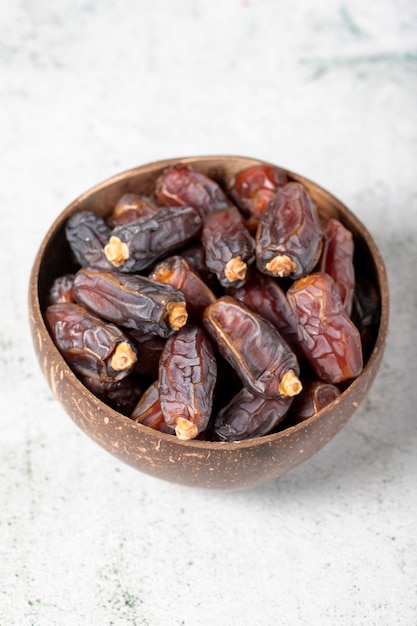 Date fruit on stone background Organic Medjoul dates in a glass bowl Ramadan food close up