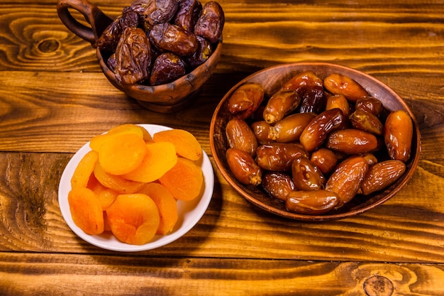 Foto daten en gedroogde abrikozen op een houten tafel