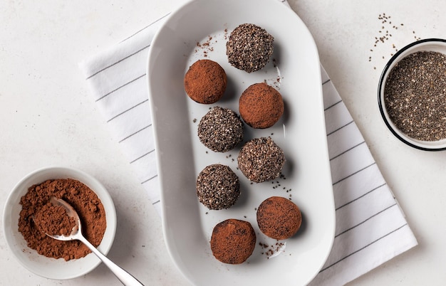 Dates chia seeds and cacao bliss balls on white plate Healthy vegan energy bites