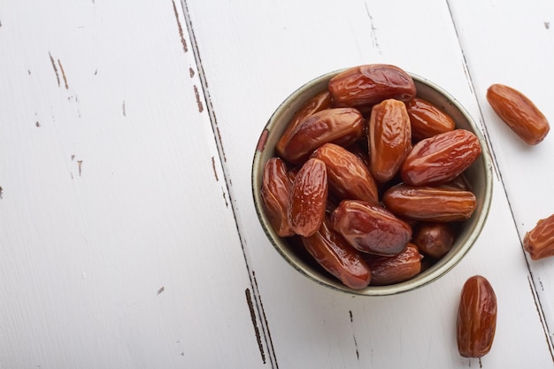 Dates food in a bowl on white background copy space top view