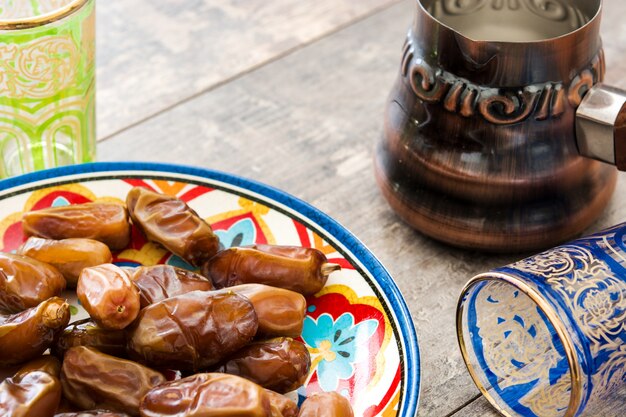 Dates food in plate and tea on wooden table