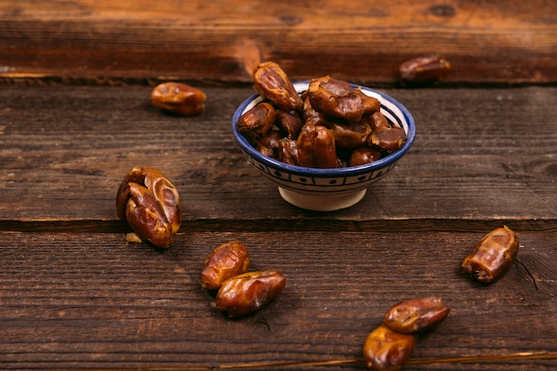 Foto le date fruttificano in ciotola sulla tavola di legno