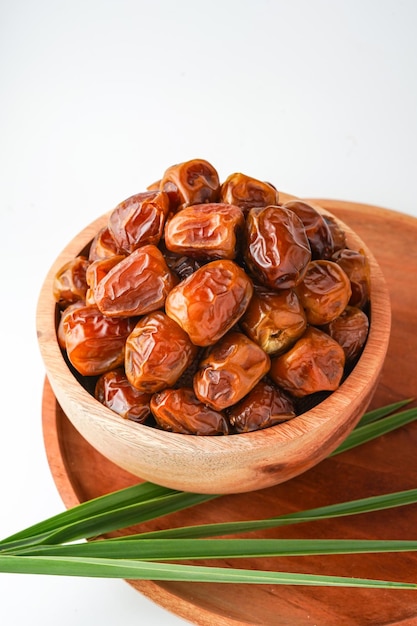 白い背景に隔離された木製の鉢にの果実のシュクール (kurma sugar) を入れています