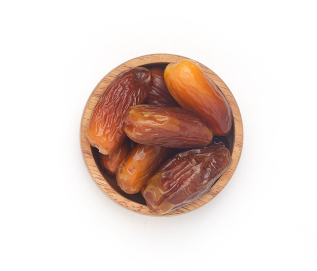 Dates fruit in wooden bowl isolated on white backgroundFruits of the Middle Easthealthy fruit top view