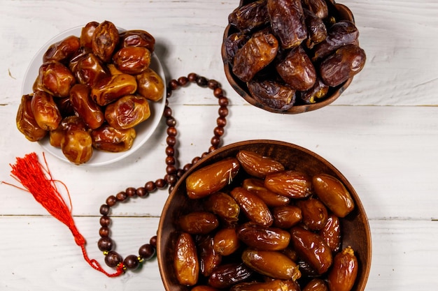 Datums fruit en rozenkrans op witte houten tafel bovenaanzicht