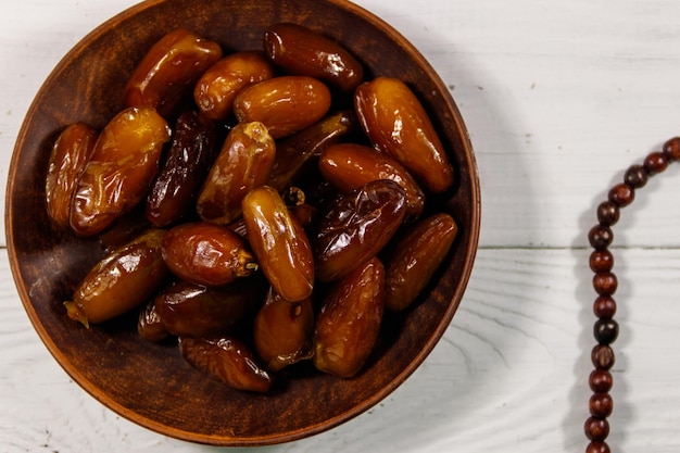 Datums fruit en rozenkrans op witte houten tafel bovenaanzicht