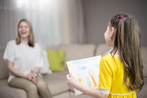 Daughter congratulates mom and gives her painting