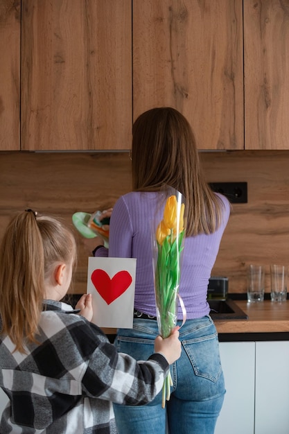 Foto la figlia si congratula con la mamma per il biglietto della festa della mamma con cuore e fiori