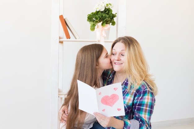 Daughter congratulates mother and gives her postcard