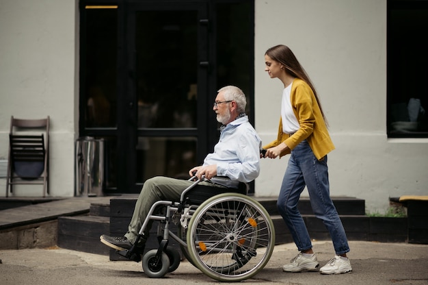 Daughter and disabled father go for a walk